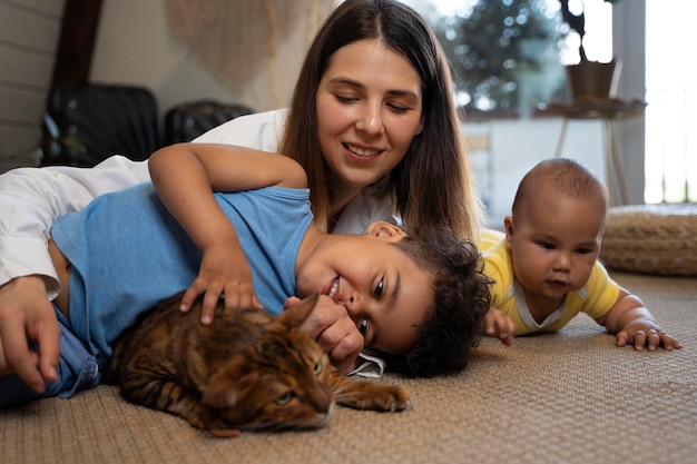 Mittelgroße Mutter mit Kindern und Katze