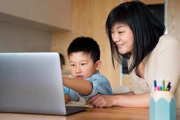 Mittelgroße Mutter und Kind mit Laptop