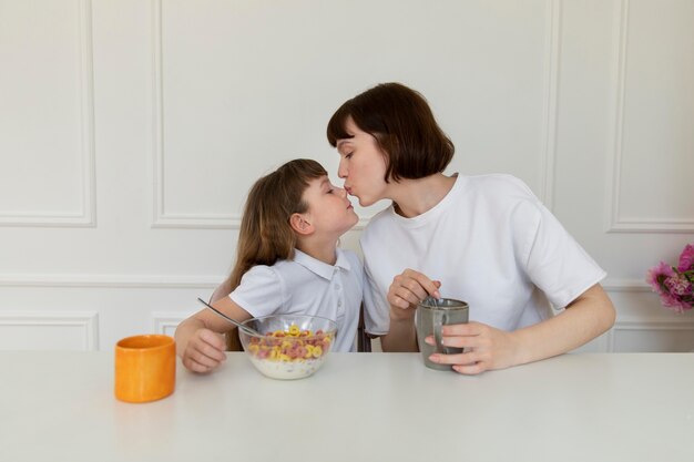 Mittelgroße Mutter und Mädchen sitzen zusammen