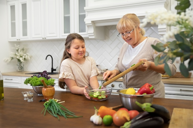 Mittelgroße Oma und Mädchen kochen