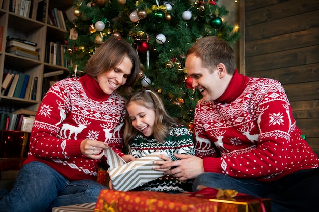 Kostenloses Foto mittelgroße smiley-familie mit geschenk