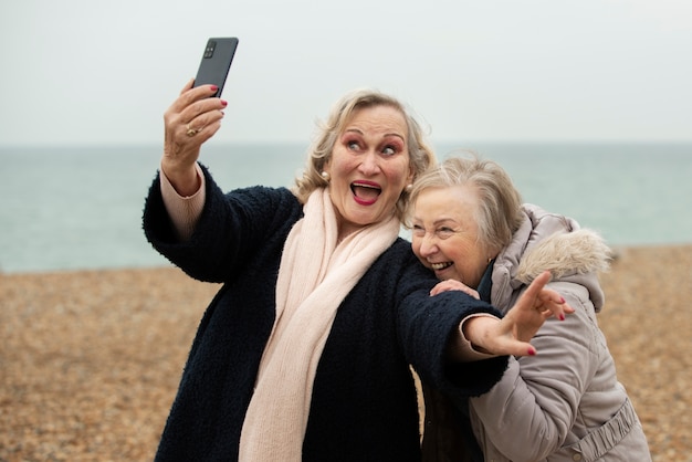 Mittelgroße Smiley-Frauen, die sich am Meer selbst machen