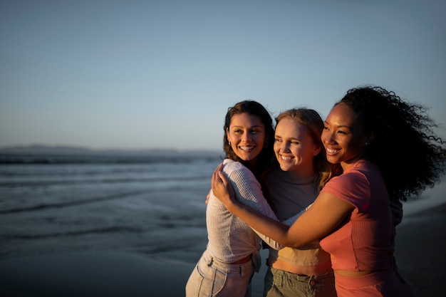 Mittelgroße Smiley-Frauen, die sich am Meer umarmen