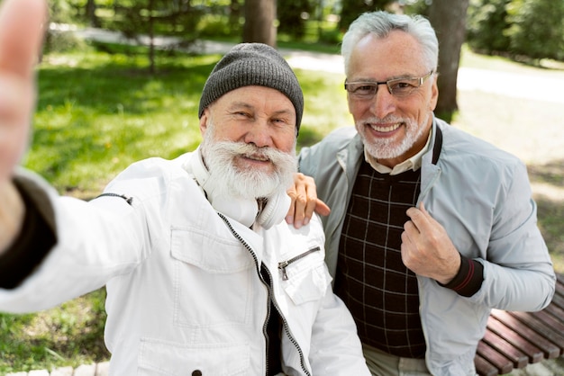 Kostenloses Foto mittelgroße smiley-männer, die selfies machen