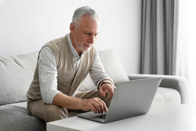 Mittelgroßer älterer Mann mit Laptop