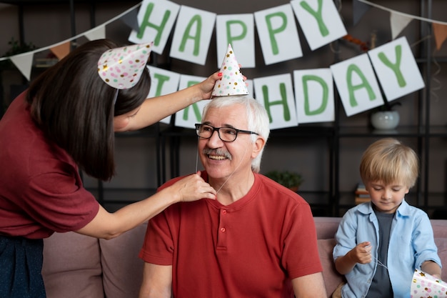 Mittelgroßer älterer Mann mit Partyhut