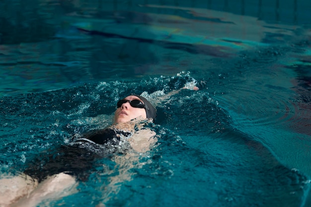 Mittelgroßer Athlet, der mit Brille schwimmt