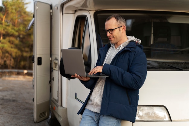 Kostenloses Foto mittelgroßer mann, der am laptop arbeitet