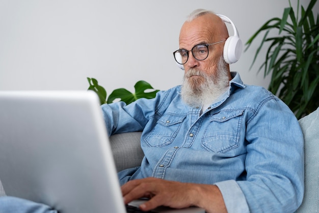 Kostenloses Foto mittelgroßer mann, der auf der couch studiert