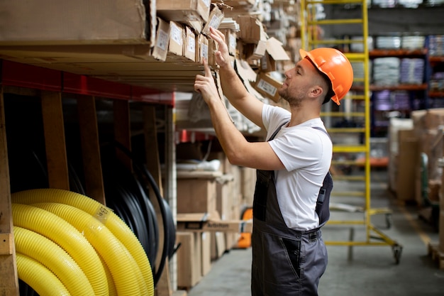 Kostenloses Foto mittelgroßer mann, der im lager arbeitet