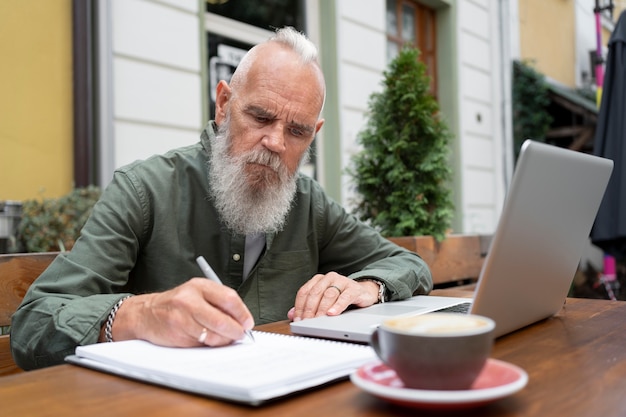 Mittelgroßer Mann, der mit Laptop studiert