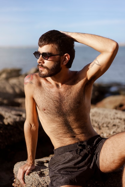 Kostenloses Foto mittelgroßer mann mit behaarter brust am meer