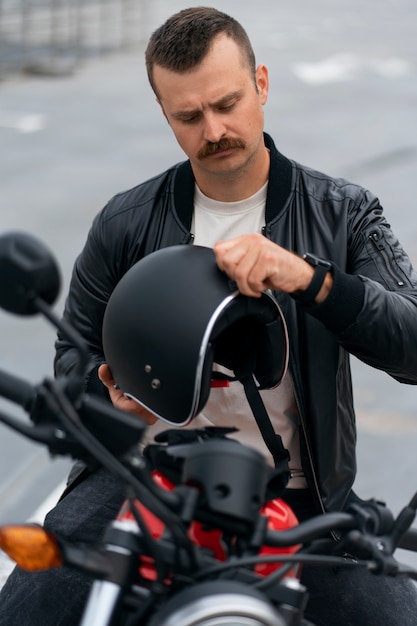 Kostenloses Foto mittelgroßer mann mit motorrad im freien