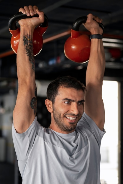 Kostenloses Foto mittelgroßer mann trainiert im fitnessstudio
