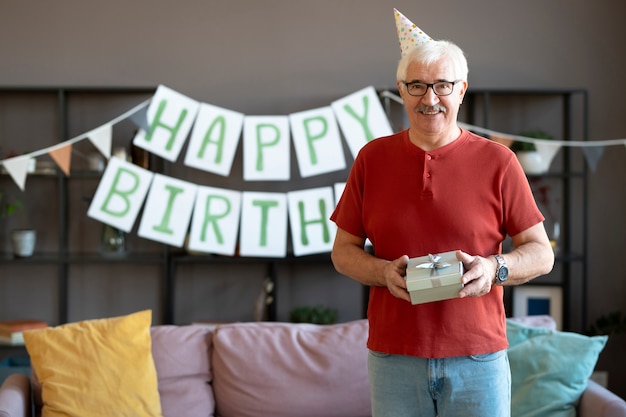 Kostenloses Foto mittelgroßer smiley-mann mit geschenk