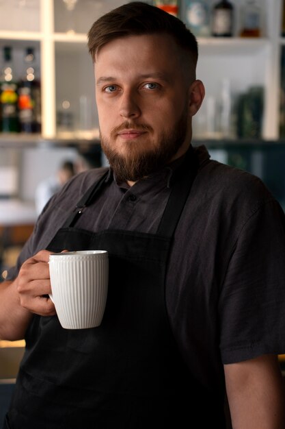 Mittelgroßer, übergroßer Mann, der als Barista arbeitet