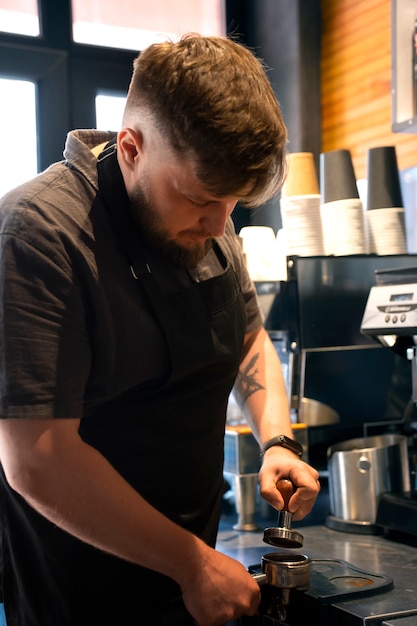 Mittelgroßer, übergroßer Mann, der als Barista arbeitet