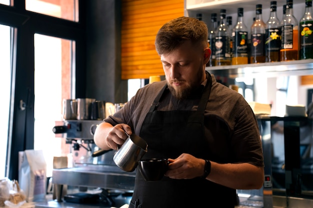 Mittelgroßer, übergroßer Mann, der als Barista arbeitet