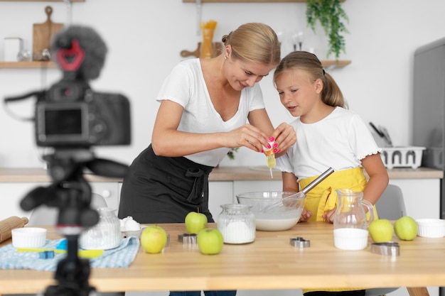 Mittelgroßes Mädchen und Frau, die zusammen kochen