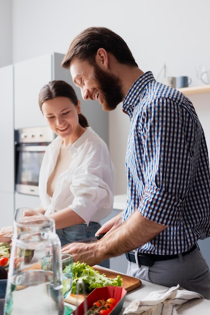 Kostenloses Foto mittelgroßes paar, das gemeinsam essen zubereitet