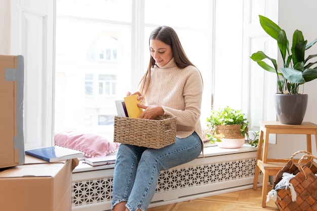 Mittelhohe Frau, die Bücher arrangiert