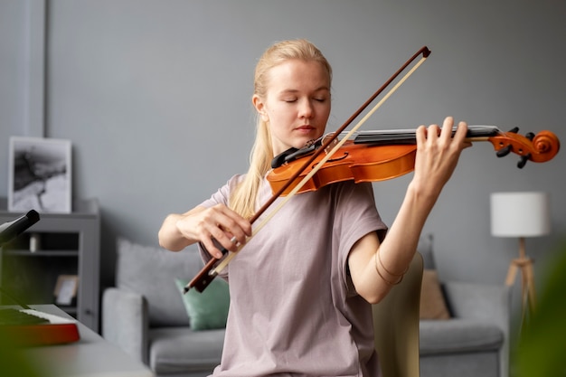 Kostenloses Foto mittelhohe frau, die geige spielt