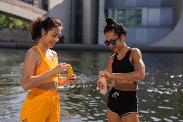 Mittelhohe Frauen mit Banane und Wasser