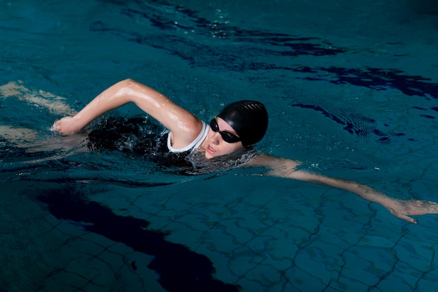 Mittelhoher Schwimmer mit Schwimmbrille im Pool