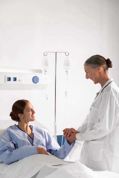 Mittelschuss Arzt und Patient Händchen haltend
