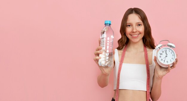 Mittelstarke Frau mit Flasche und Uhr