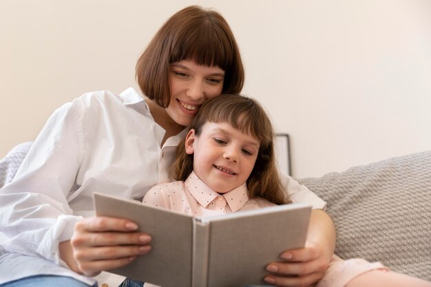 Mittelstarke Mutter und Mädchen lesen Buch