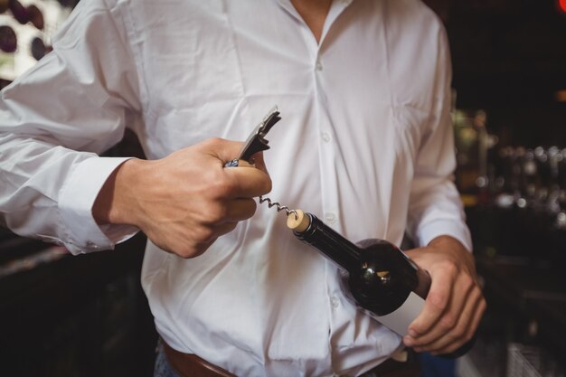 Mittelteil der Bar Tender öffnet eine Flasche Wein