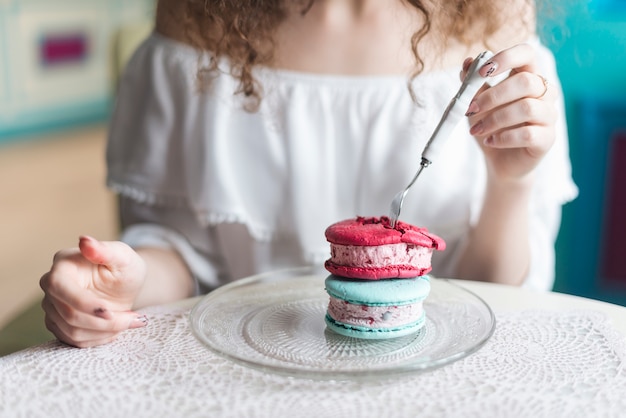 Mittelteil der frau eiscremesandwich mit gabel essend