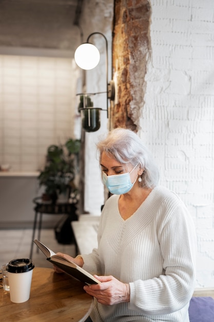 Kostenloses Foto mittlere aufnahme alte frau mit maske