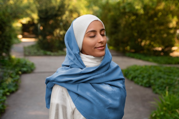 Kostenloses Foto mittlere aufnahme einer frau in halal-kleidung im freien