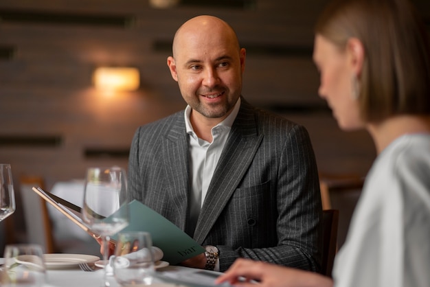 Mittlere Aufnahme eines Paares beim Mittagessen in einem Luxusrestaurant