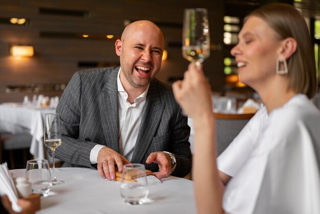 Mittlere Aufnahme eines Paares beim Mittagessen in einem Luxusrestaurant