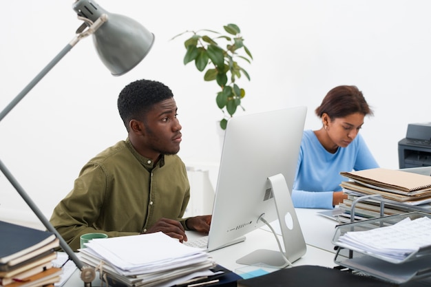 Kostenloses Foto mittlere aufnahme gelangweilter menschen bei der arbeit