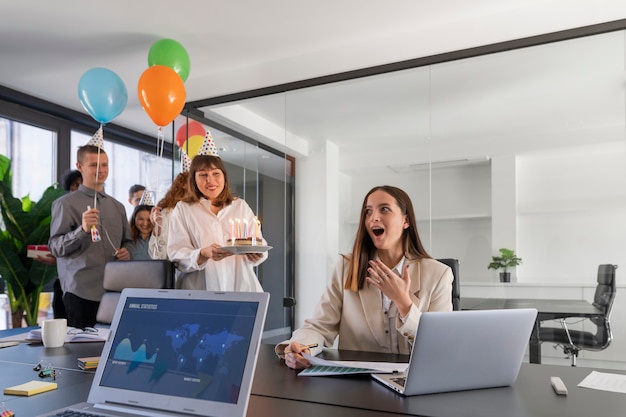 Kostenloses Foto mittlere aufnahme glückliche menschen, die im büro feiern