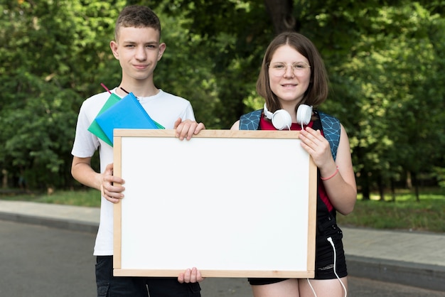 Mittlere Aufnahme Gymnasiasten halten Whiteboard