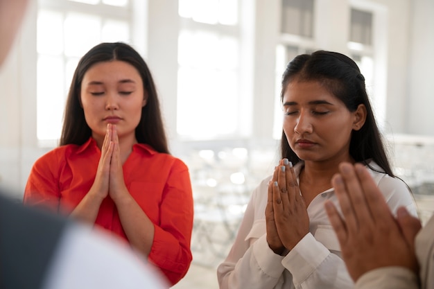 Kostenloses Foto mittlere aufnahme junger menschen beim beten in der kirche