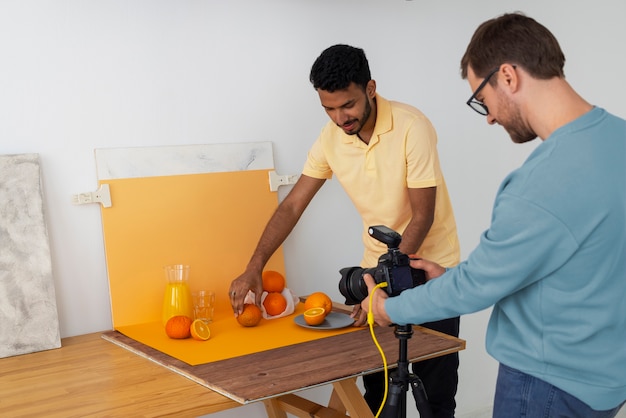 Kostenloses Foto mittlere aufnahme spezialisierte fotografen, die im studio arbeiten