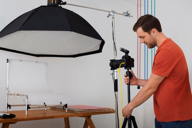 Mittlere Aufnahme spezialisierter Fotograf, der im Studio arbeitet