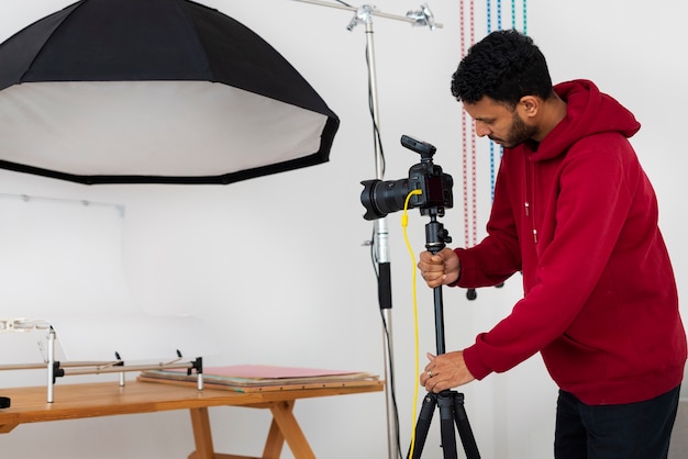 Mittlere Aufnahme spezialisierter Fotograf, der im Studio arbeitet