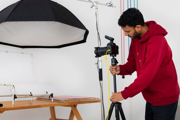 Mittlere Aufnahme spezialisierter Fotograf, der im Studio arbeitet