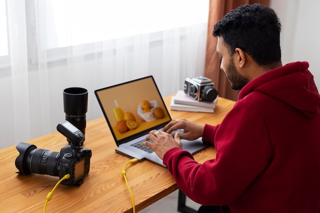 Mittlere Aufnahme spezialisierter Fotograf, der im Studio arbeitet