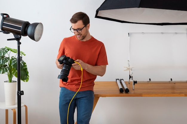 Mittlere Aufnahme spezialisierter Fotograf, der im Studio arbeitet