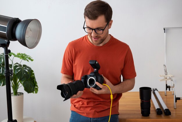 Mittlere Aufnahme spezialisierter Fotograf, der im Studio arbeitet