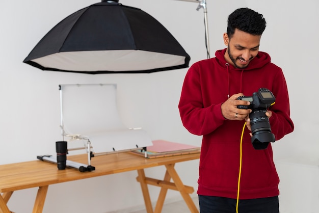 Mittlere Aufnahme spezialisierter Fotograf, der im Studio arbeitet