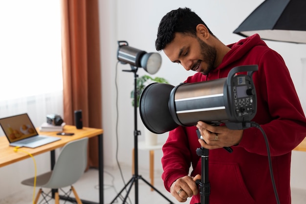 Mittlere Aufnahme spezialisierter Fotograf, der im Studio arbeitet